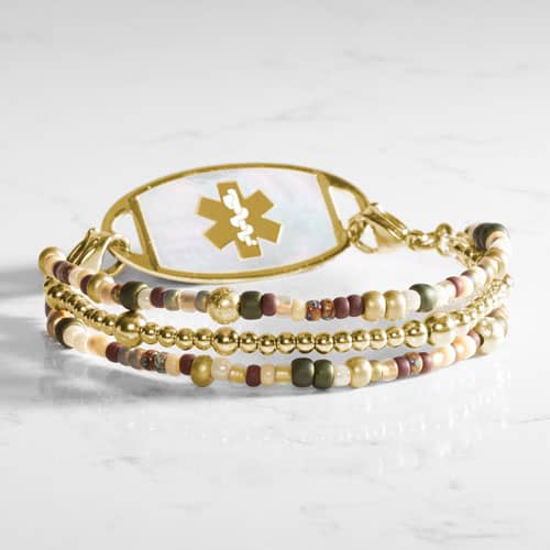 Gold-tone multi-strand medical ID bracelet with cream, burgundy, green, and multicolor beads and a medical symbol tag.