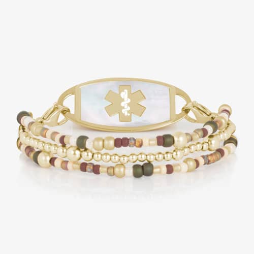 Gold-tone multi-strand medical ID bracelet with a light-colored inlay tag, medical symbol, and mixed beaded accents.
