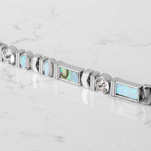 Close Up Of Rhodium and palladium plated herringbone medical ID bracelet with abalone, opal, crystal, and moon stone accents paired with abalone medical ID tag.