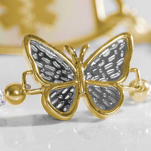 Up close detail of a gold plated butterfly centerpiece with decorative silver details.