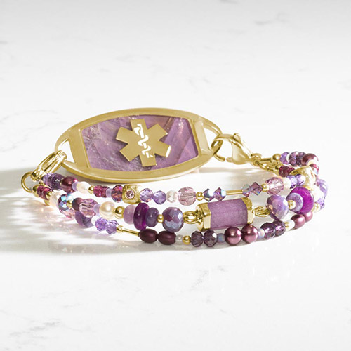 Violet Beaded Medical ID Bracelet, shown on wrist, showcasing rich purple and gold hues with a faceted jade centerpiece