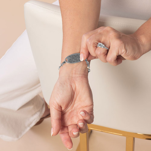 Woman displays the custom, laser engraving on the back of her medical Id tag.