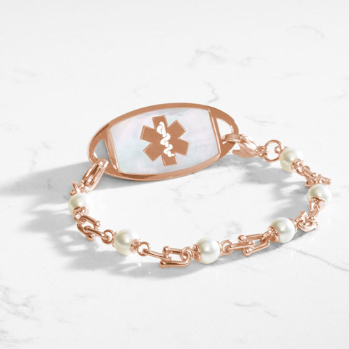 Bridle links in rose gold paired with luminous faux pearls and attached to a rose gold medical ID tag with inlaid mother of pearl.