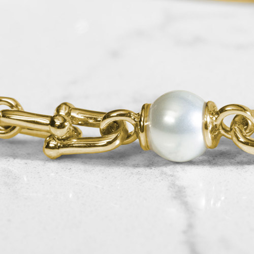 Close up of Bridle links in gold paired with luminous faux pearls.