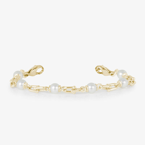 Bridle links in gold paired with luminous faux pearls and attached to a gold medical ID tag with inlaid mother of pearl.