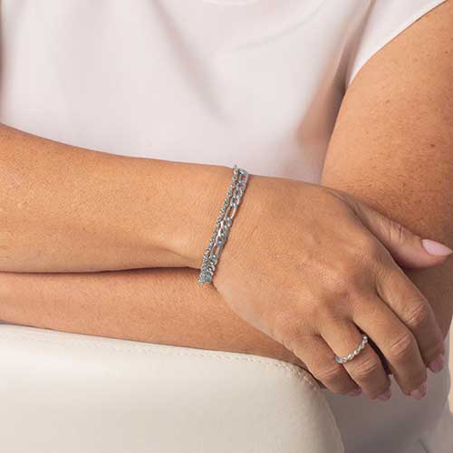 Woman wearing a silver toned two chain medical alert bracelet.