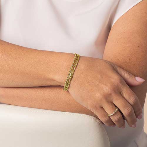 Woman wearing a gold toned two chain medical alert bracelet.