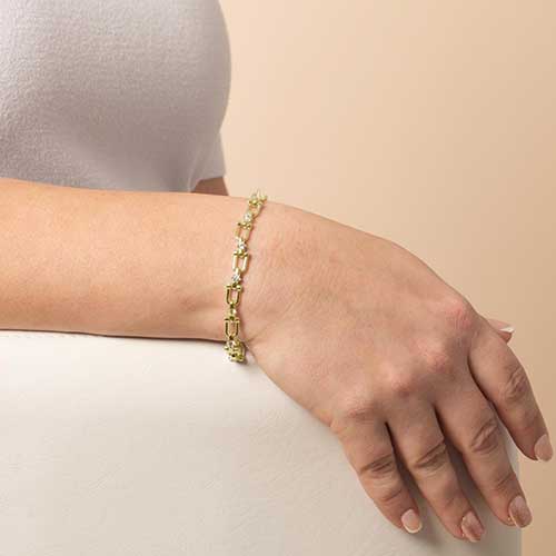 Woman wearing a gold and CZ-accented chain link bracelet
