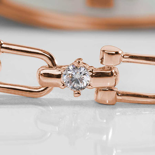 Close-up of rose gold medical alert bracelet chain featuring a round-cut clear CZ accent set in a polished double-link design.