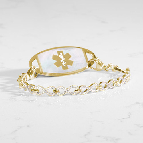 Gold infinity-link medical ID bracelet with clear CZ accents and a gold medical tag inset with white mother-of-pearl.