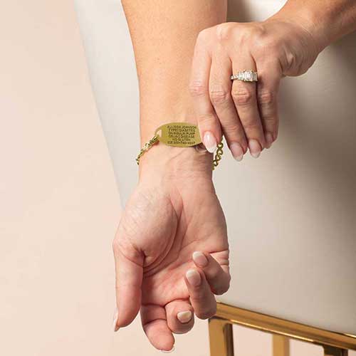 Lauren’s Hope engraved gold medical ID bracelet on model’s wrist, showing custom emergency engraving with ICE contact information for safety.