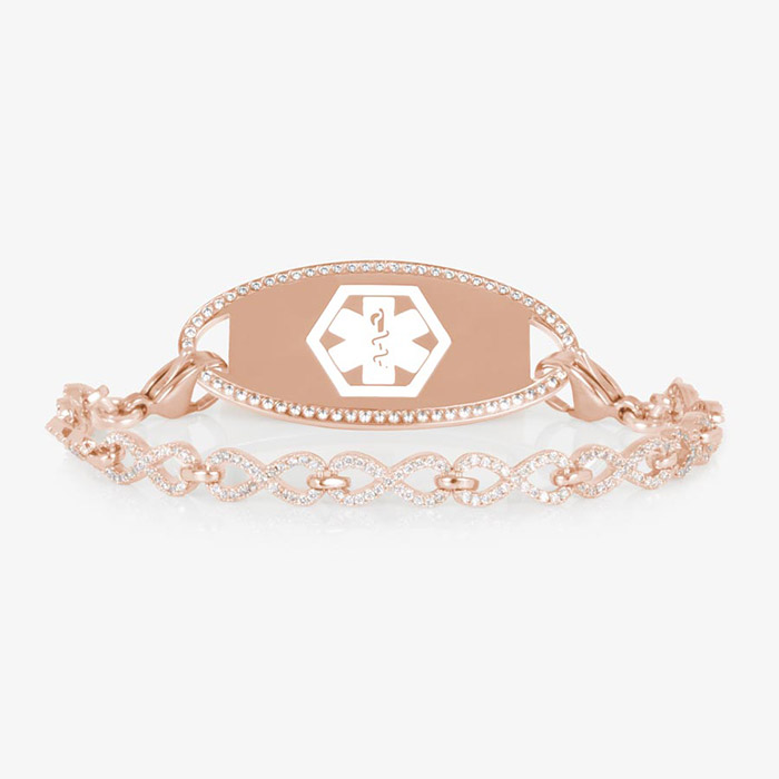 Rose gold medical ID bracelet with a CZ-framed tag engraved with a white medical symbol, paired with a rose gold chain of linked infinity shapes covered in sparkling clear crystals.