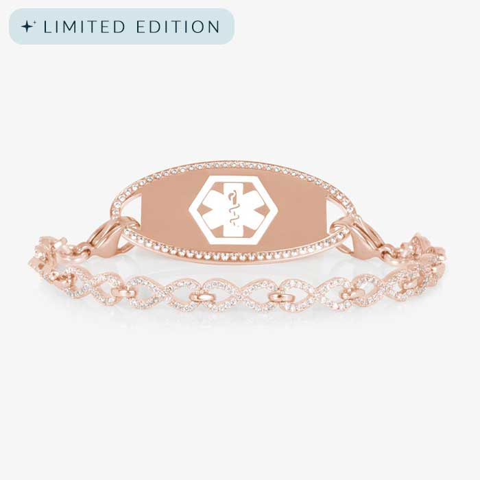 Rose gold medical ID bracelet with a CZ-framed tag engraved with a white medical symbol, paired with a rose gold chain of linked infinity shapes covered in sparkling clear crystals.