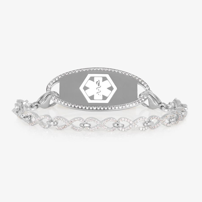 Silver medical ID bracelet with an infinity-link chain encrusted in clear CZs, paired with a matching oval tag outlined in crystals.