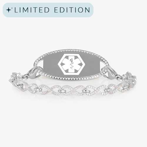 Silver medical ID bracelet with an infinity-link chain encrusted in clear CZs, paired with a matching oval tag outlined in crystals.