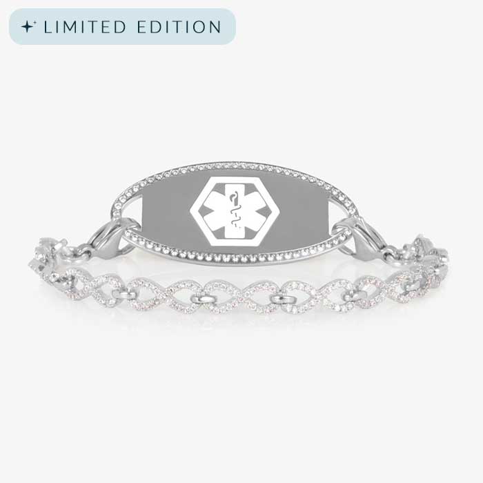 Silver medical ID bracelet with an infinity-link chain encrusted in clear CZs, paired with a matching oval tag outlined in crystals.