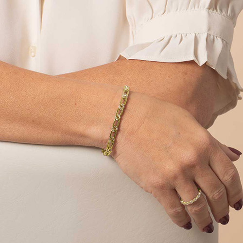 Model wearing the Harper Gold bracelet with chain link design and CZ accents, styled alongside a matching gold ring for a polished, coordinated look.