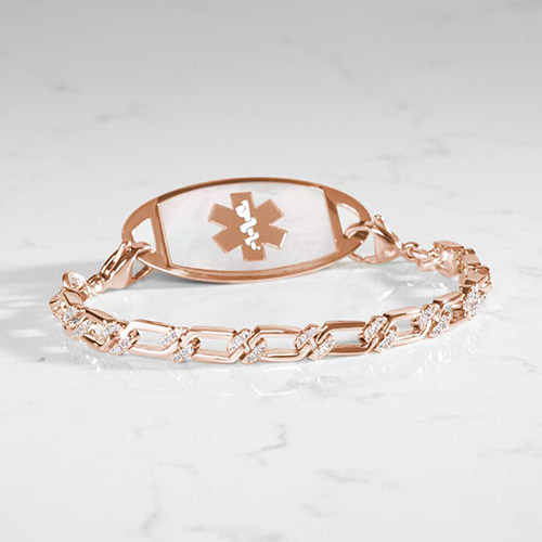 Elegant rose gold medical ID bracelet shown from the back, featuring a mother-of-pearl inlay and CZ-accented links on a marble surface.