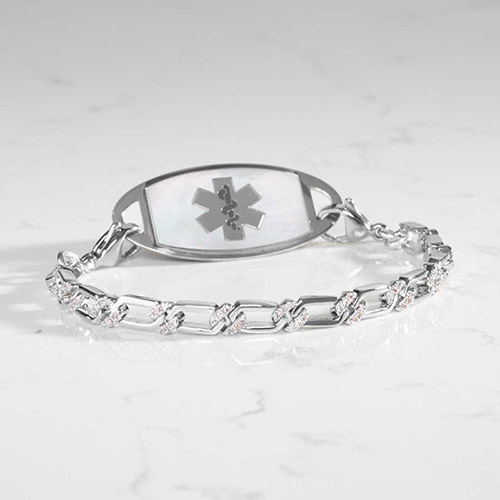 Silver Harper medical ID bracelet displayed on marble background, showcasing the mother-of-pearl inlay and CZ-accented chain.