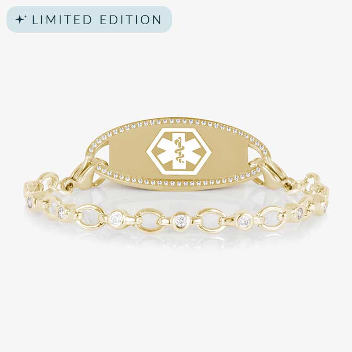 Jovie Medical ID bracelet in gold with clear CZs and an oval gold ID tag bordered with crystals, featuring a white medical symbol.