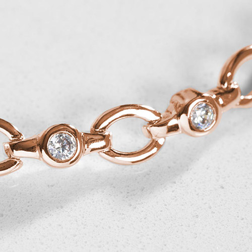 Close-up of rose gold bracelet links with bezel-set clear CZ crystals.