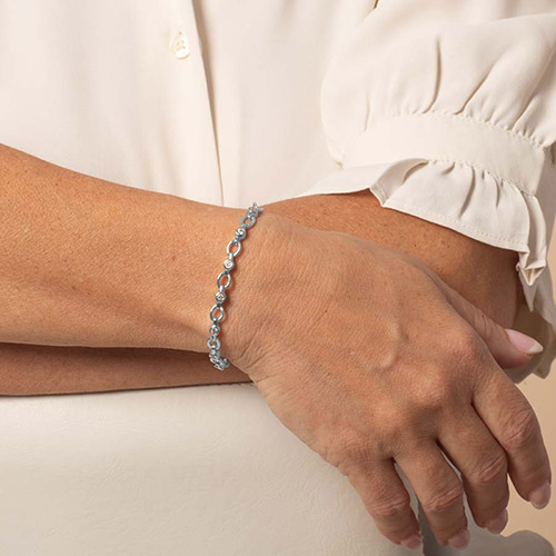Silver Jovie bracelet worn alone, showing a delicate line of crystal-accented links around the wrist.