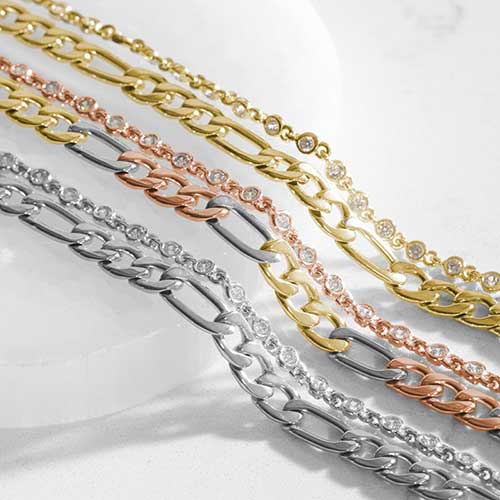 Mixed metal bracelet chains in gold, rose gold, and silver finishes with crystal accents, displayed as interchangeable medical ID bracelet strands.