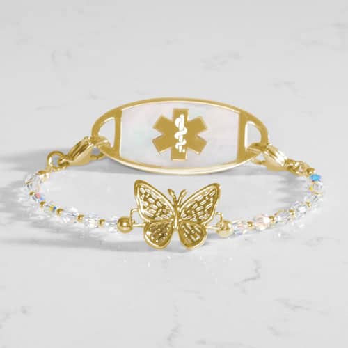 Gold medical ID bracelet featuring a butterfly charm, white beaded chain, and Star of Life emblem plaque for stylish everyday safety.