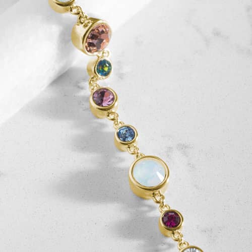 Close-up of the Mia Gold bracelet highlighting colorful bezel-set crystals, luminous opal accents, and polished gold-tone craftsmanship.