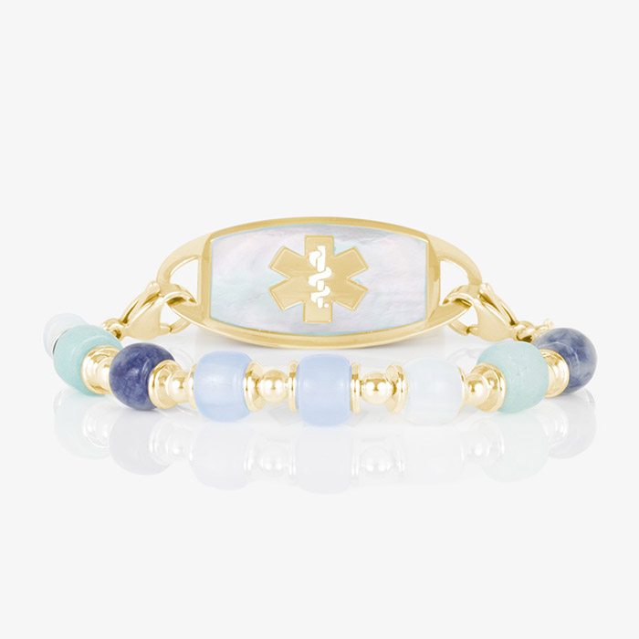 Gold-tone medical alert bracelet with mother-of-pearl ID tag, Star of Life symbol, and blue aqua Selene beads for elegant safety.