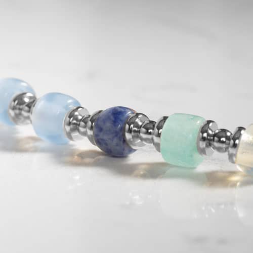 Close-up of the Selene bracelet featuring blue gemstone-inspired beads, aqua accents, and polished silver-tone spacers.