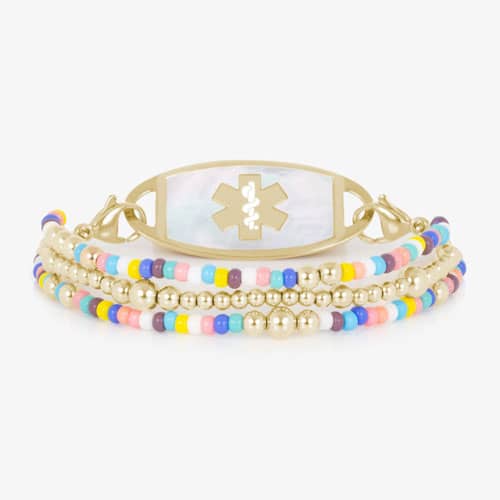 Oval medical ID tag with white inlay and medical symbol attached to a gold tone beaded bracelet with colorful seed beads.