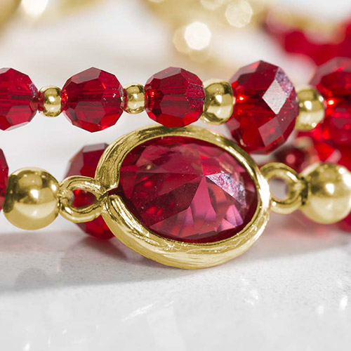 Close-up of bracelet details on Holly Medical Alert Bracelet, highlighting red pearls, gold accents, and a bezel-set red crystal centerpiece