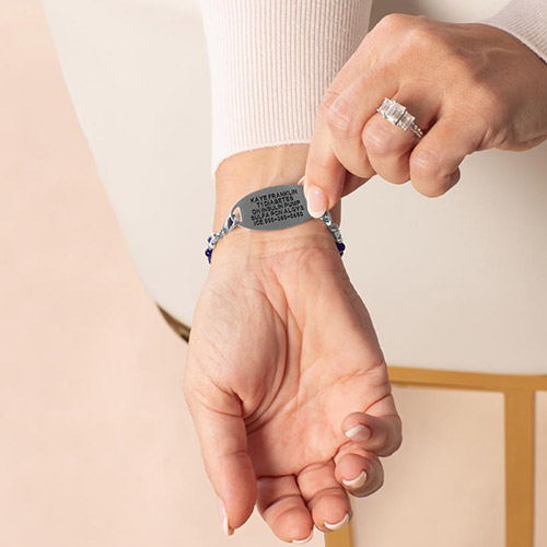 Woman showing custom laser engraved medical alert tag