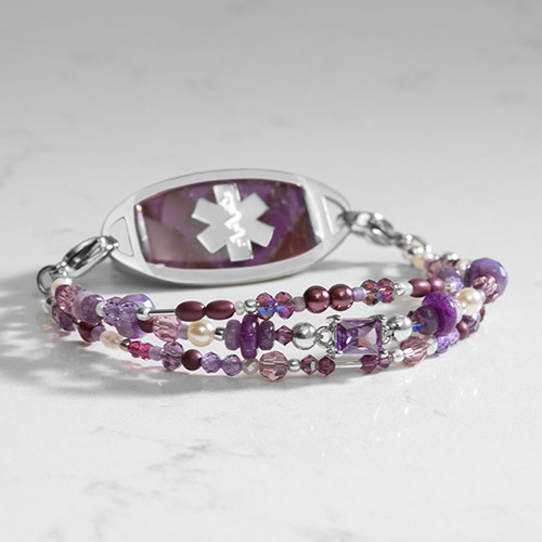 Amethyst and purple medical alert bracelet with silver and purple beads on marble background