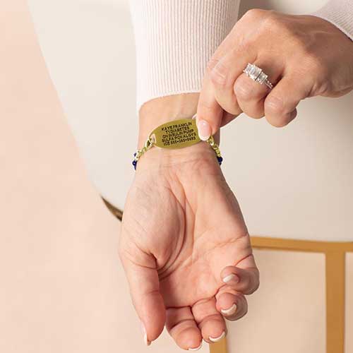 Woman showing custom laser engraved medical alert tag