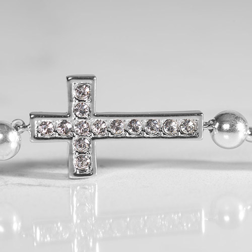 Close-up of crystal cross on Faith Silver Medical Alert Bracelet – Sparkling horizontal and vertical rows of clear CZs set in a polished silver cross, flanked by round silver beads.