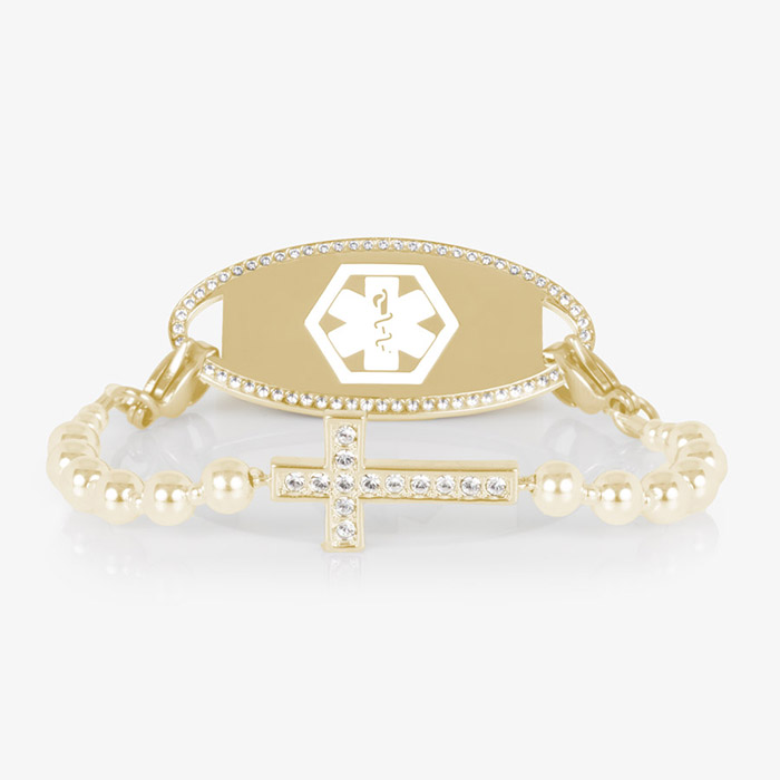 Gold medical ID bracelet with CZ-accented border and cross charm, displayed on a white background