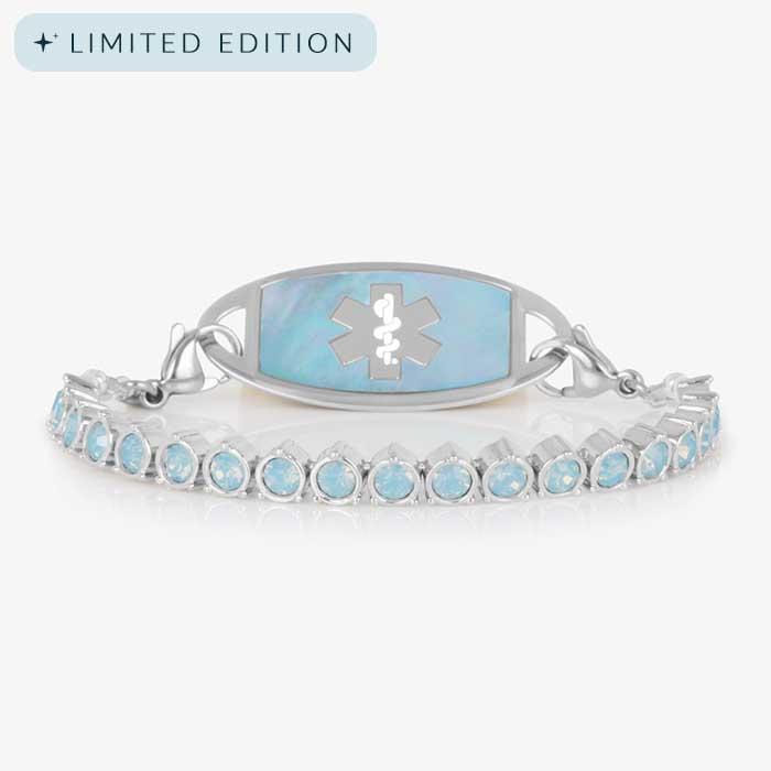 Straight-on product image of a silver medical ID bracelet with iridescent blue opal stones and a matching ID tag featuring a silver medical caduceus symbol.