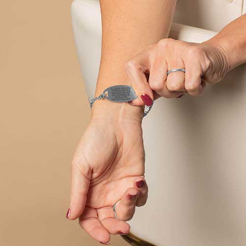 Woman displaying the custom, laser engraved, medical info on her medical alert ID tag.