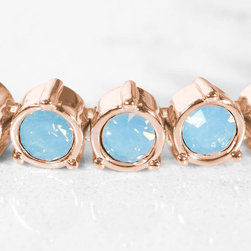 Close-up of rose gold medical ID bracelet links featuring bezel-set light blue opal crystals in a round setting.