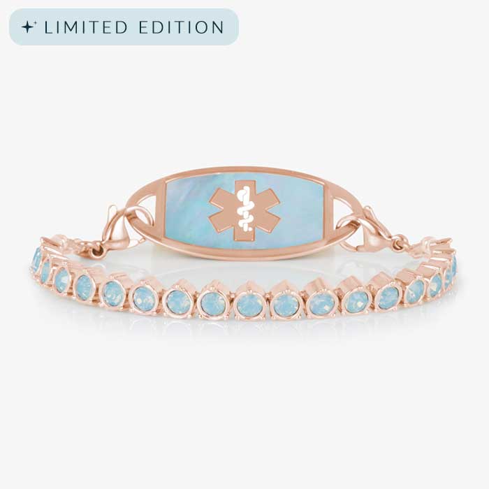 Rose gold medical ID bracelet with opal inlay tag and light blue opal crystal links, shown against a white background.