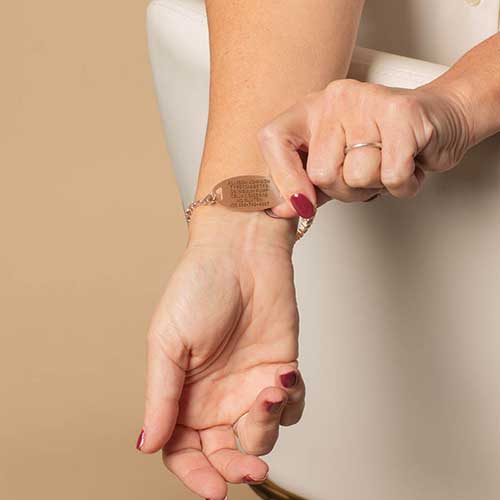 Woman displaying the custom, laser engraved, medical info on her medical alert ID tag.