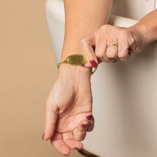 Woman displaying the custom, laser engraved, medical info on her medical alert ID tag.