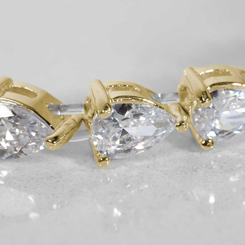Close-up view of teardrop-cut cubic zirconia stones in gold prong settings on a women's medical ID bracelet.