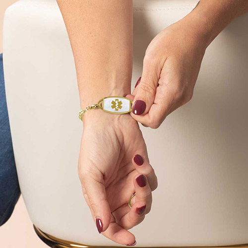 Woman wearing an elegant gold and clear CZ tennis bracelet with coordinating gold and CZ ring.