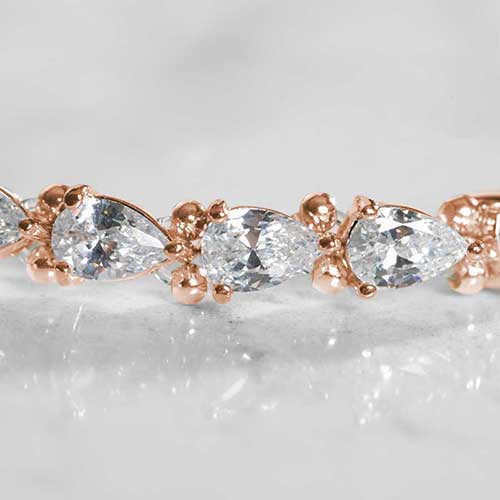 Close-up of pear-shaped cubic zirconia stones in rose gold prong settings on a stretch medical ID bracelet, showcasing the sparkle and elegant detailing.