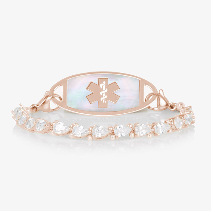Jackie Rose stretch medical ID bracelet featuring 14k rose gold plating, pear-cut CZs, and a white mother-of-pearl tag with engraved medical symbol, shown on a white background.