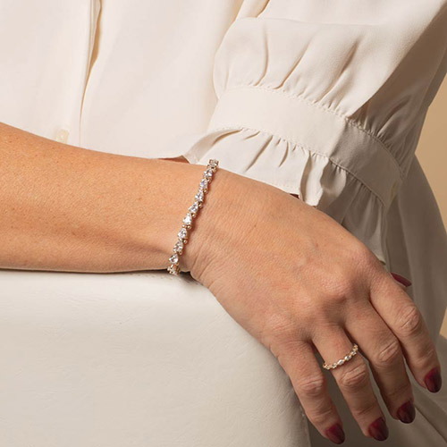 Stylish rose gold medical alert bracelet featuring a row of sparkling heart-shaped stones, modeled on wrist with matching ring.