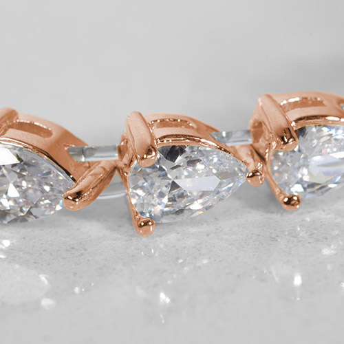 Close-up of pear-shaped cubic zirconia stones in rose gold prong settings on a stretch medical ID bracelet, showcasing the sparkle and elegant detailing.